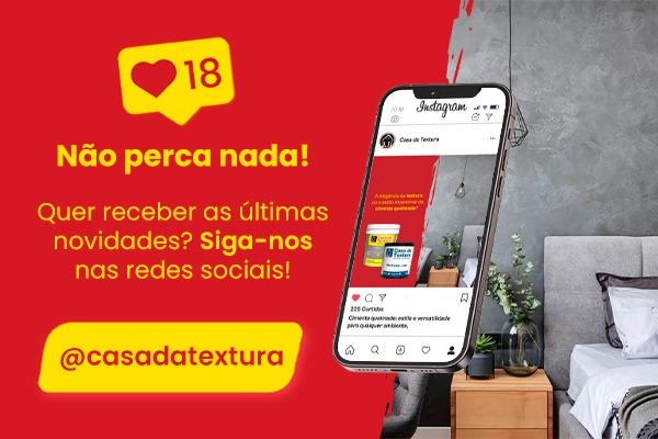 Celular exibindo produtos Casa da Textura com fundo de parede em cimento queimado e textura vermelha, incentivando o público a seguir nas redes sociais.